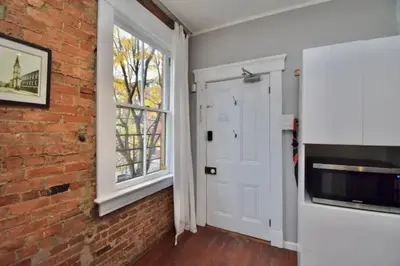 a living room with a brick wall and a window at Walk to Everything - Sports, Food, Music, Downtown in Cincinnati