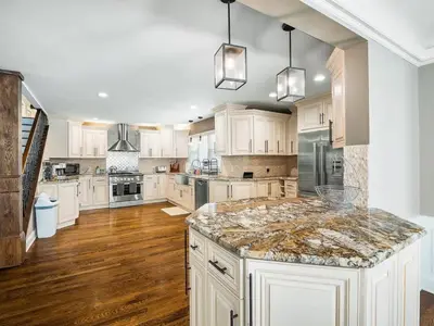 a large kitchen with white cabinets and a marble counter top at Shaker Prestige - 4 000 sq ft - Calm and Quiet in Shaker Heights