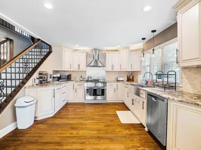 a kitchen with white cabinets and a staircase at Shaker Prestige - 4 000 sq ft - Calm and Quiet in Shaker Heights
