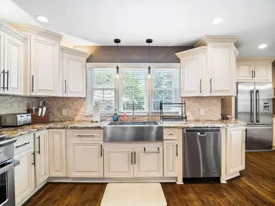 a kitchen with white cabinets and a stainless steel sink at Shaker Prestige - 4 000 sq ft - Calm and Quiet in Shaker Heights