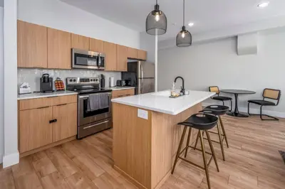 a kitchen with wooden cabinets and a white counter top at Prime OTR, 1 Block to TQL, Cali King Bed, Sleeps 4ppl, Free Light Rail, Smart TVs in Over-The-Rhine