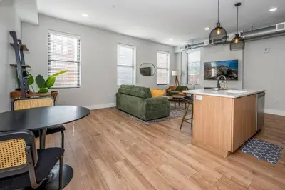 a kitchen and living room with a table and a couch at Prime OTR, 1 Block to TQL, Cali King Bed, Sleeps 4ppl, Free Light Rail, Smart TVs in Over-The-Rhine