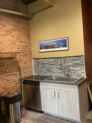 a kitchen with a sink and a brick wall at Downtown Cleveland Historic District in Cleveland
