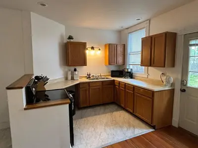 a kitchen with wooden cabinets and a sink at Eighty Three-Historic Downtown in Chillicothe