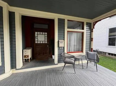 a porch with two chairs and a table and a door at Eighty Three-Historic Downtown in Chillicothe
