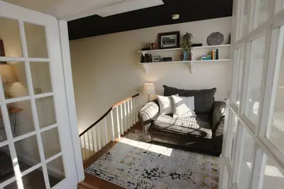 a living room with a couch and a staircase at The Loft Downtown in Chillicothe