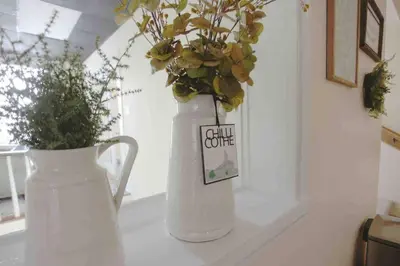 a white vase with flowers in it on a counter at The Loft Downtown in Chillicothe