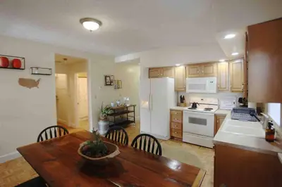 a kitchen with a wooden table and white appliances at The Loft Downtown in Chillicothe