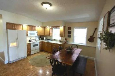 a kitchen with a table and a white refrigerator at The Loft Downtown in Chillicothe