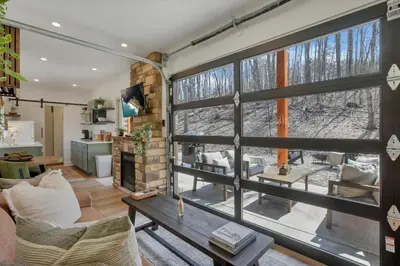 a living room with a large window and a couch at The Hillside Retreat - Cozy container home with Hot tub and Fire pit in Logan