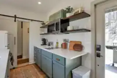 a kitchen with blue cabinets and a white counter top at The Hillside Retreat - Cozy container home with Hot tub and Fire pit in Logan