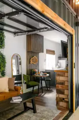 a living room with a couch and a table at The Hillside Retreat - Cozy container home with Hot tub and Fire pit in Logan