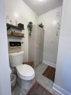 a white bathroom with a toilet and a shower at The Hillside Retreat - Cozy container home with Hot tub and Fire pit in Logan