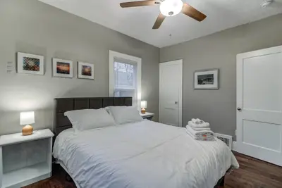 a bedroom with a large bed with a ceiling fan at The Gallery House - Art curated by local artist! in Cleveland Heights