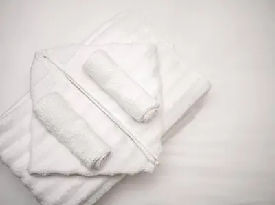 two rolls of white towels sitting on top of a bed at The Gallery House - Art curated by local artist! in Cleveland Heights