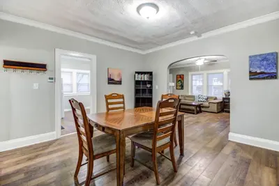 a dining room with a wooden table and chairs at The Gallery House - Art curated by local artist! in Cleveland Heights
