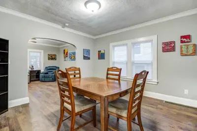 a dining room with a wooden table and chairs at The Gallery House - Art curated by local artist! in Cleveland Heights