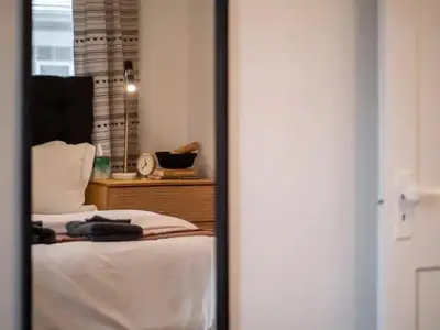 a reflection of a bedroom with a bed and a mirror at Classic Meets Contemporary I Minutes to Cle Clinic in Cleveland Heights