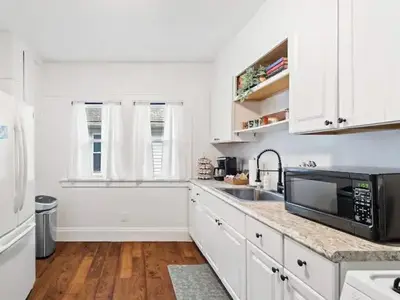 a white kitchen with a sink and a microwave at Classic Meets Contemporary I Minutes to Cle Clinic in Cleveland Heights