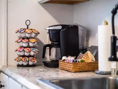 a kitchen counter with cupcakes on a rack next to a sink at Classic Meets Contemporary I Minutes to Cle Clinic in Cleveland Heights