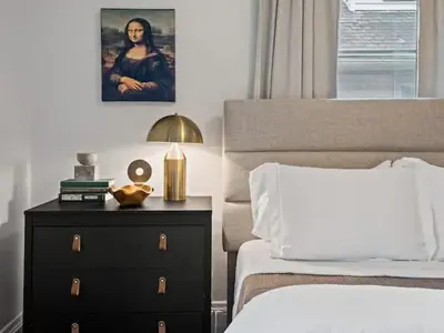 a bedroom with a bed and a nightstand with a dresser with a night at Classic Meets Contemporary I Minutes to Cle Clinic in Cleveland Heights