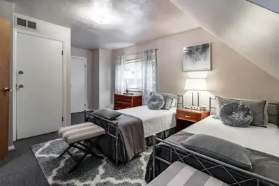 a bedroom with two beds and a chair and a window at Spacious Family Getaway - Near Cleveland Clinic in Cleveland