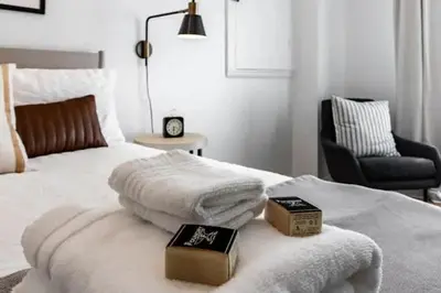 a bedroom with a bed with two books and a chair at Cute 1Bed Loft at The Foundry - Steps to Riverside in Cleveland