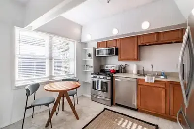 a kitchen with a table and a stove and a sink at Cute 1Bed Loft at The Foundry - Steps to Riverside in Cleveland
