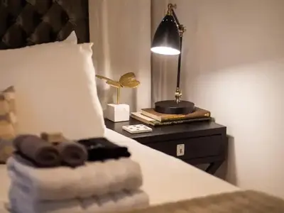 a bedroom with a bed with a lamp on a table at Newly Renovated - Professionally Designed - 2 BR in Lakewood