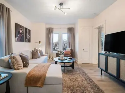 a living room with a white couch and a tv at Newly Renovated - Professionally Designed - 2 BR in Lakewood