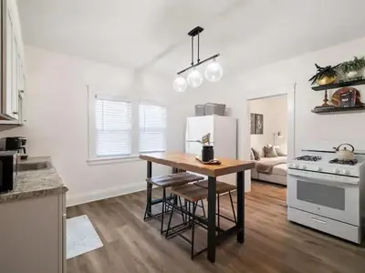 a kitchen with a table and a stove and refrigerator at Newly Renovated - Professionally Designed - 2 BR in Lakewood