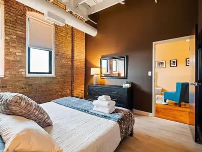 a bedroom with a large bed and a mirror at Lakefront Loft - Walk 2 First Energy x Progressive in Cleveland