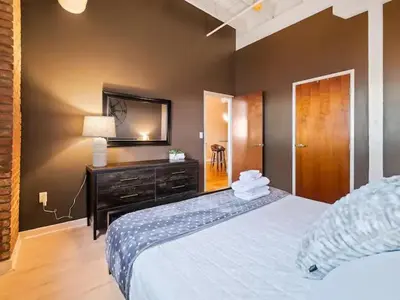 a bedroom with a bed with a dresser and a mirror at Lakefront Loft - Walk 2 First Energy x Progressive in Cleveland