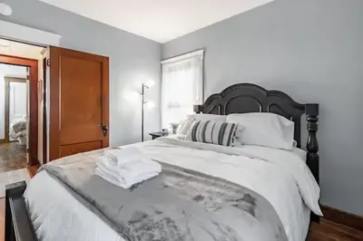 a bedroom with a large bed with a black headboard at Lakewood Bed & Biscuit - Pet Friendly - Mins to LKWD Park in Lakewood