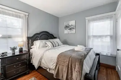 a bedroom with a large bed and two windows at Lakewood Bed & Biscuit - Pet Friendly - Mins to LKWD Park in Lakewood