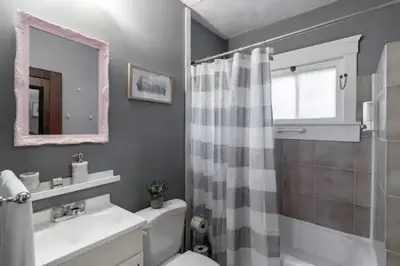 a bathroom with a sink and a toilet and a mirror at Lakewood Bed & Biscuit - Pet Friendly - Mins to LKWD Park in Lakewood