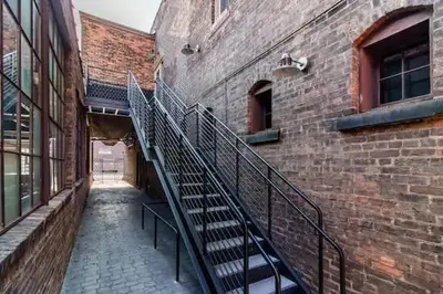 a stairway leading to a brick building with a staircase at Spacious Riverfront Suite - Close to Downtown in Cleveland