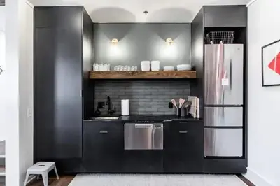 a kitchen with black walls and a stainless steel refrigerator at Spacious Riverfront Suite - Close to Downtown in Cleveland