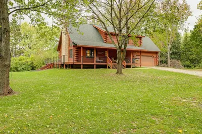 a log cabin with a porch and a tree at On-Site Lake and Gazebo Cabin in Yellow Springs! in Fairborn