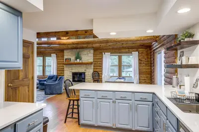 a kitchen with white cabinets and a brick wall at On-Site Lake and Gazebo Cabin in Yellow Springs! in Fairborn