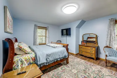 a bedroom with a bed and a dresser and a mirror at On-Site Lake and Gazebo Cabin in Yellow Springs! in Fairborn