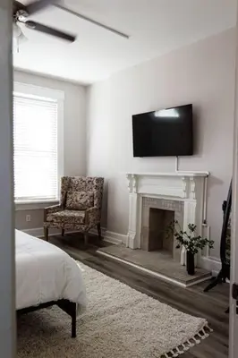 a bedroom with a fireplace and a tv on the wall at Lizzys Haven in Cincinnati