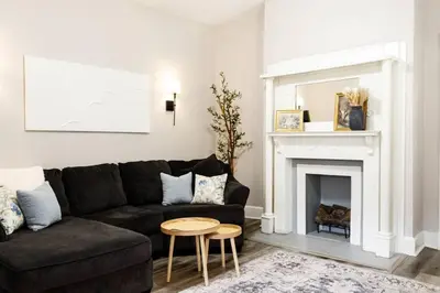 a living room with a black couch and a fireplace at Lizzys Haven in Cincinnati