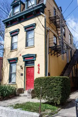 a brick house with a red door on a street at Lizzys Haven in Cincinnati