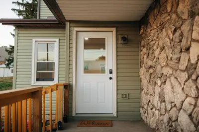 a white door on a house with a stone wall at Family Friendly Downtown Apple Creek by Antiques in Apple Creek