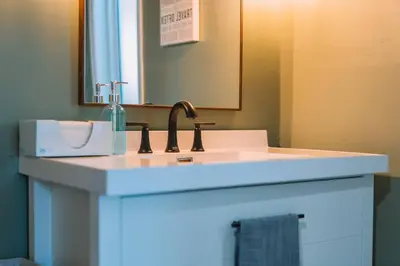 a bathroom counter with a sink and a mirror at Family Friendly Downtown Apple Creek by Antiques in Apple Creek