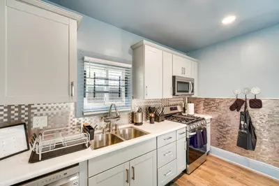 a kitchen with white cabinets and a sink at 4 Mi to Dtwn Home with Patio in Cleveland! in Cleveland