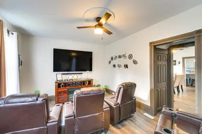 a living room with leather furniture and a flat screen tv at 4 Mi to Dtwn Home with Patio in Cleveland! in Cleveland