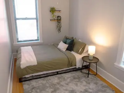 a bed in a room with a table and a window at 2 Blocks from TQL Stadium 2BR 1.5BA in Cincinnati