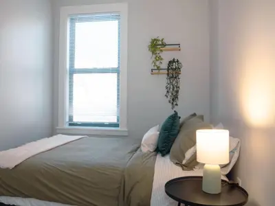 a bedroom with a bed and a table with a lamp at 2 Blocks from TQL Stadium 2BR 1.5BA in Cincinnati